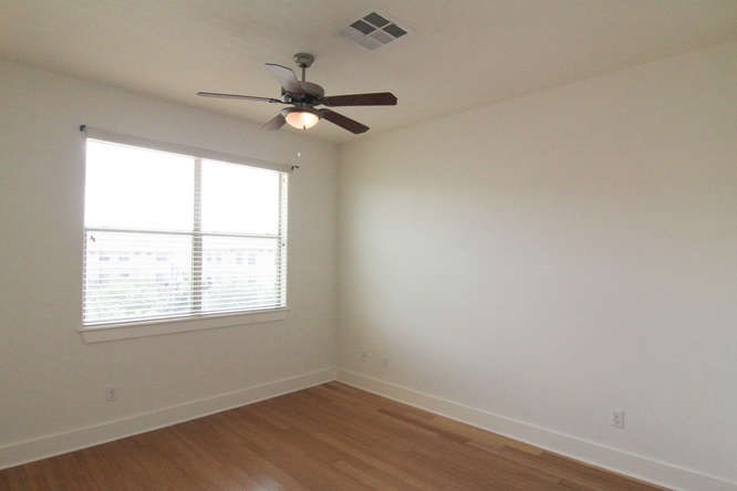 13420 Lyndhurst Street, Unit 401 408 303 Austin, TX 78717 - Photo 27 of 36 an empty room with wooden floor fan and windows