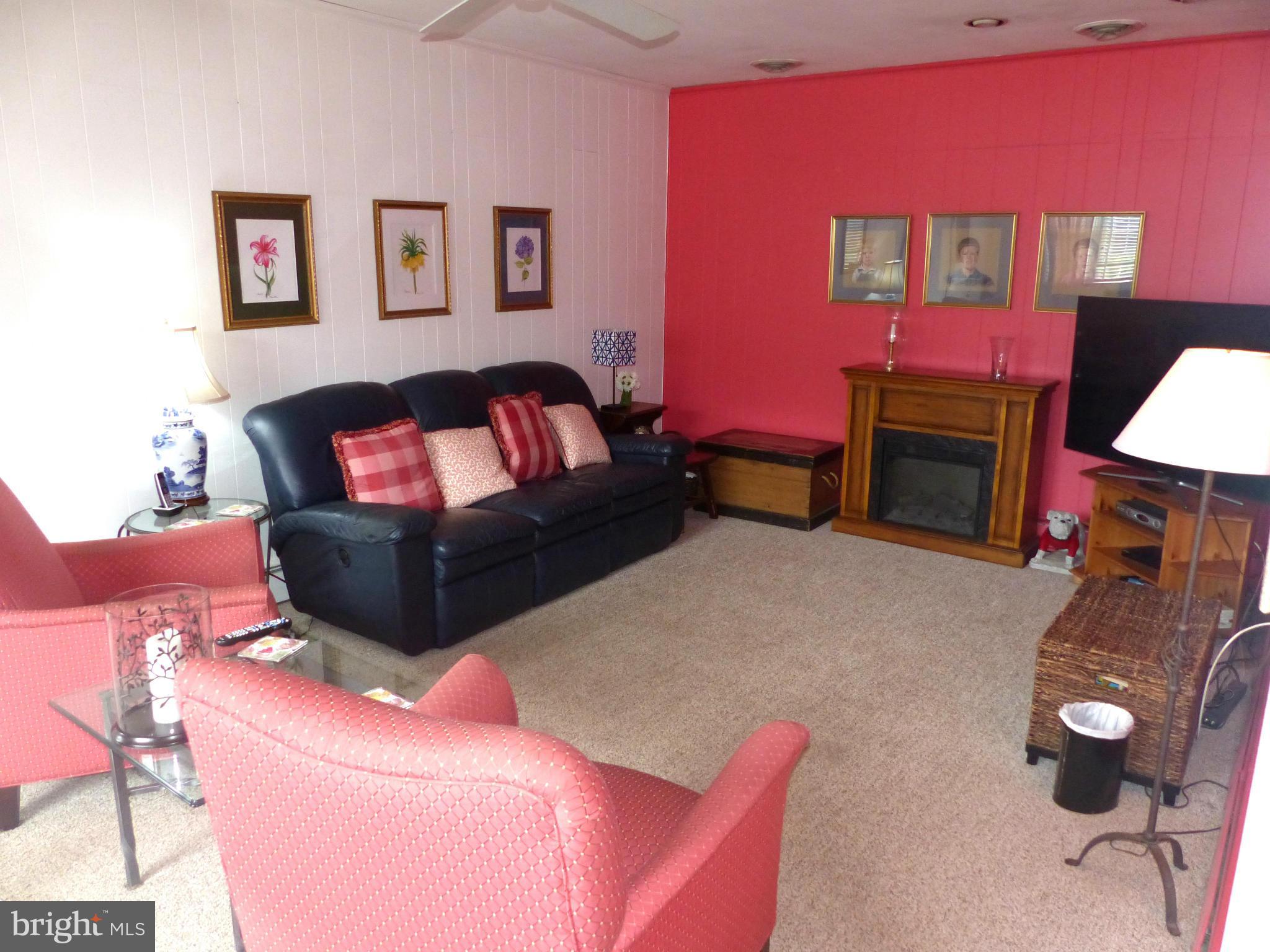 3004 Merrymans Mill Road Phoenix, MD 21131 - Photo 6 of 29 a living room with furniture a flat screen tv and a fireplace