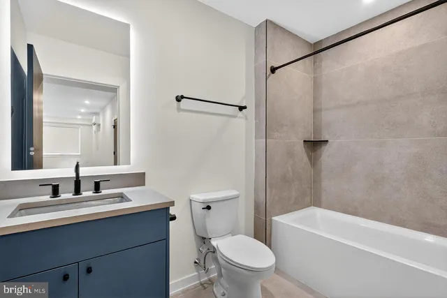 a bathroom with a sink a toilet a mirror a vanity and shower