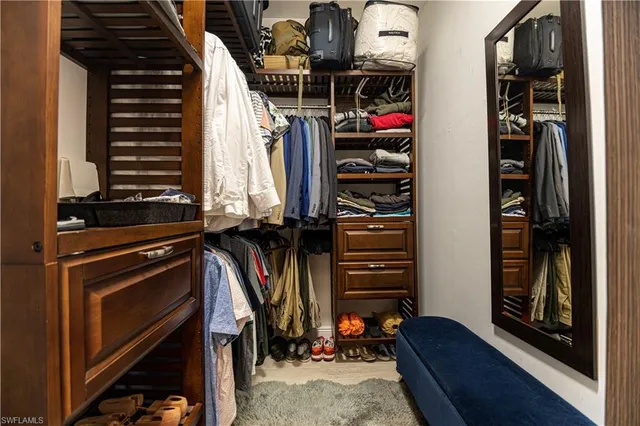 a view of walk in closet with clothes