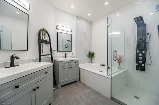 a bathroom with a double vanity sink mirror and shower