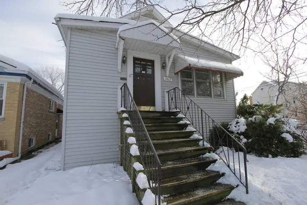 a view of a house with wooden fence and two windows