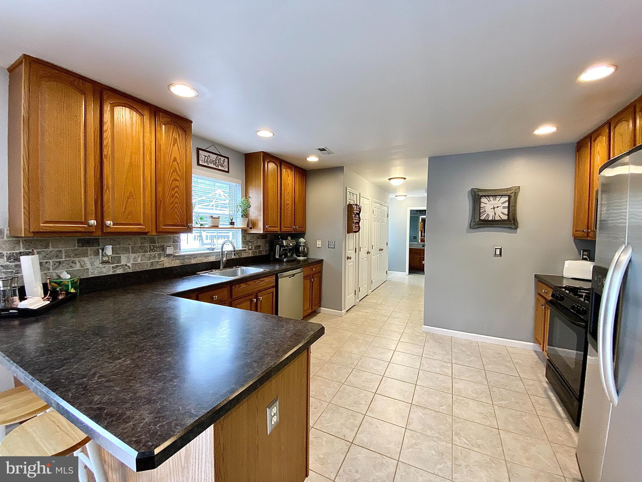8 Augusta Street Wrightstown, NJ 08562 - Photo 10 of 44 a kitchen with stainless steel appliances granite countertop a refrigerator a stove top oven a sink a dining table and chairs