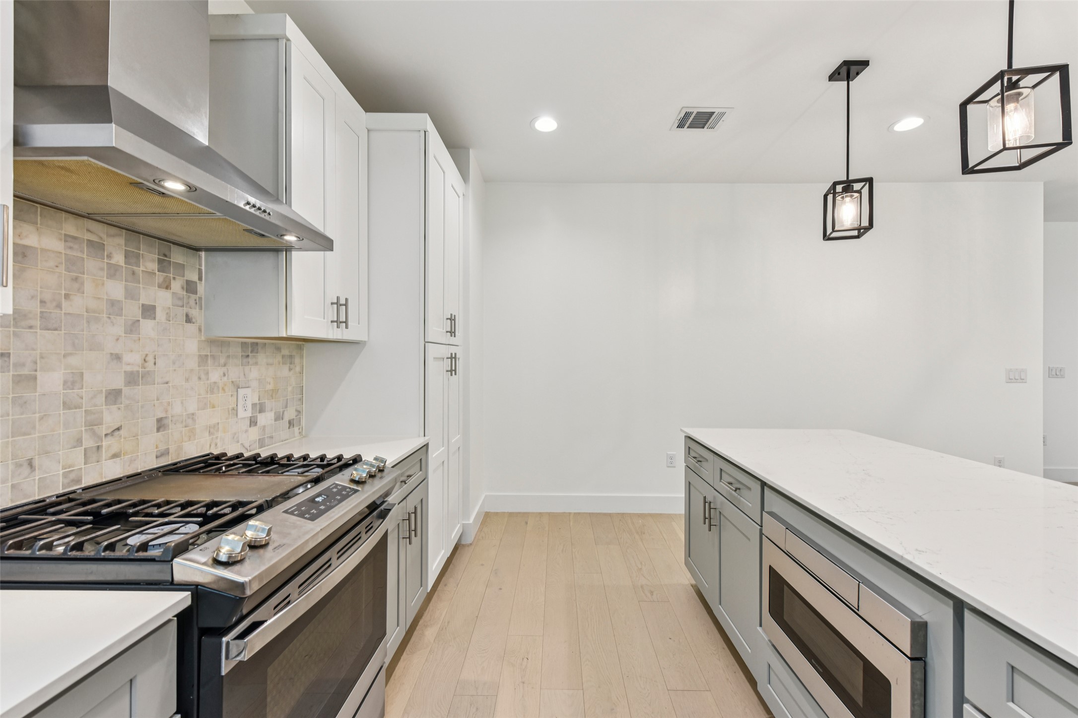 3607 Grant Street, Unit A Austin, TX 78721 - Photo 7 of 40 a kitchen with a stove and a white wooden cabinets