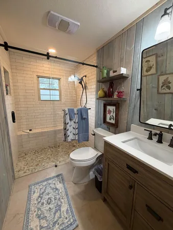 a bathroom with a sink a toilet and shower