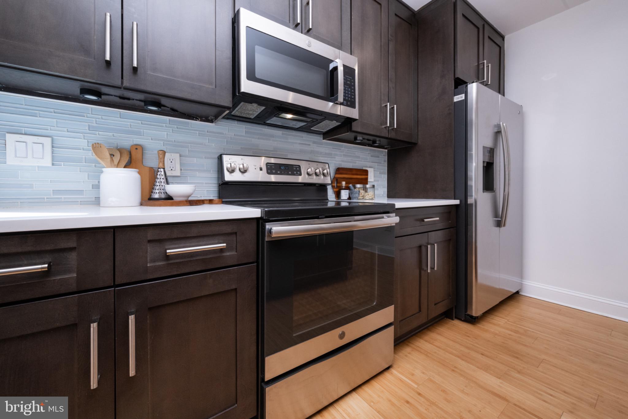 2102 Berges Street, Unit B Philadelphia, PA 19125 - Photo 9 of 29 a kitchen with stainless steel appliances granite countertop a stove microwave and refrigerator