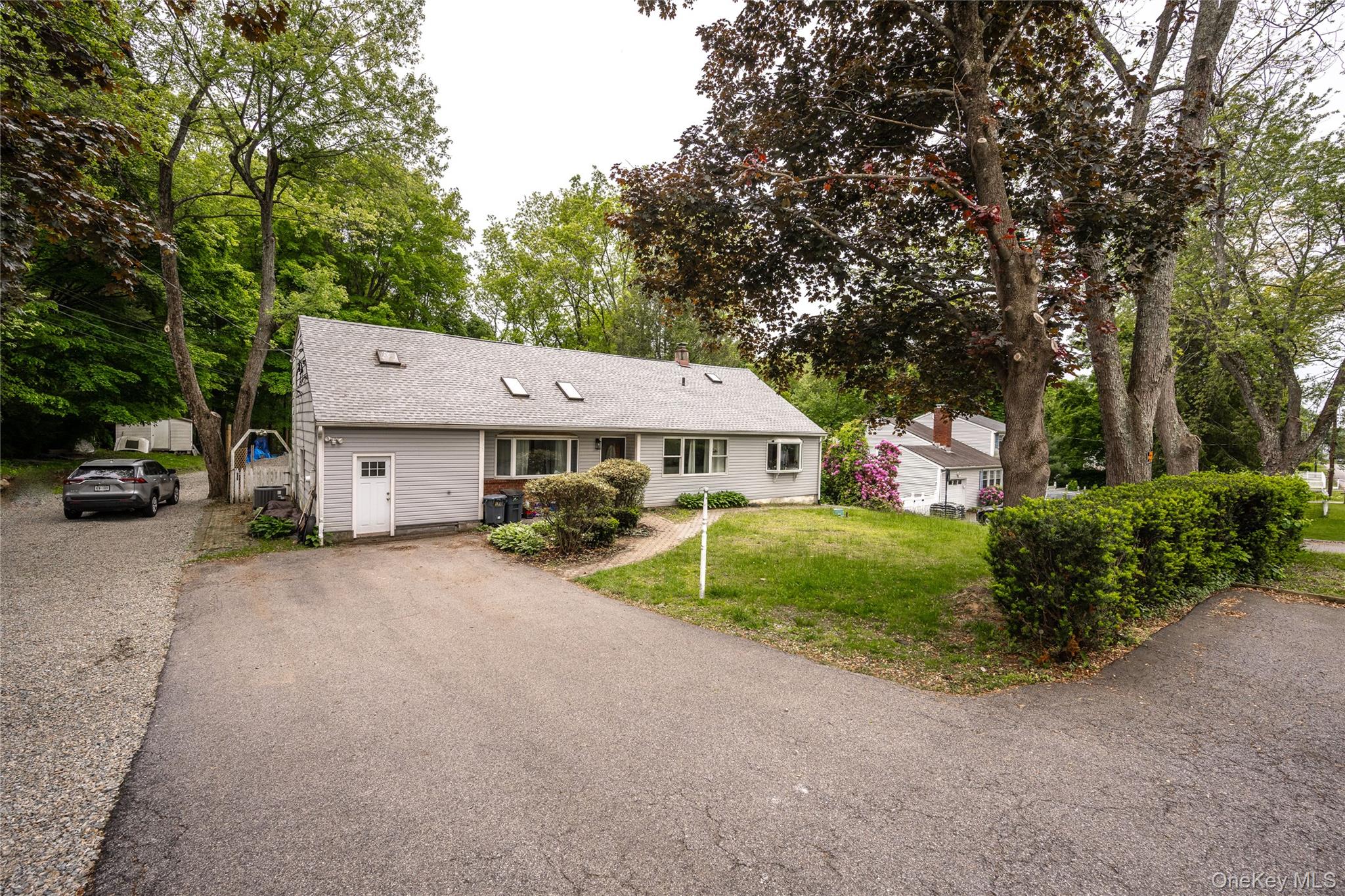 929 Fox Meadow Road Yorktown Heights, NY 10598 - Photo 35 of 39 Ranch-style home with asphalt driveway, a shingled roof, a front lawn, and view of scattered trees