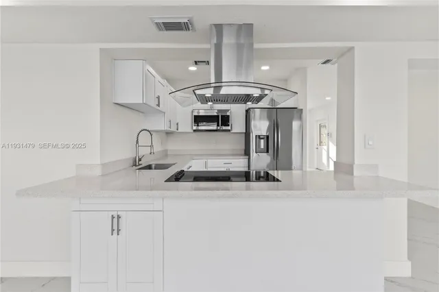 a kitchen with stainless steel appliances a refrigerator sink and cabinets