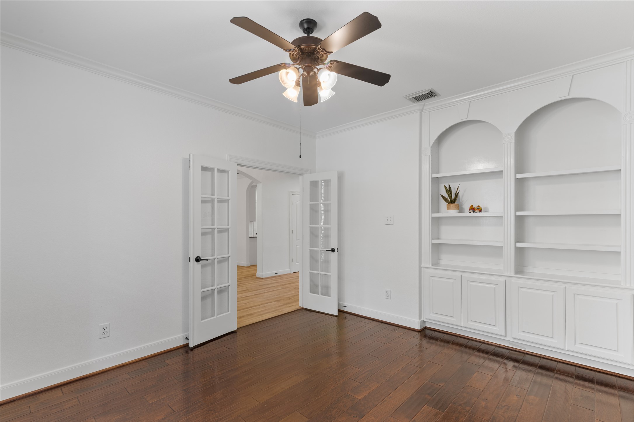 155 South Arrow Canyon Circle Spring, TX 77389 - Photo 7 of 49 This quiet and organized home office at the entrance of the home has built-in bookshelves, french doors, and refined wood flooring. The room is well-lit and offers a comfortable and quiet workspace.