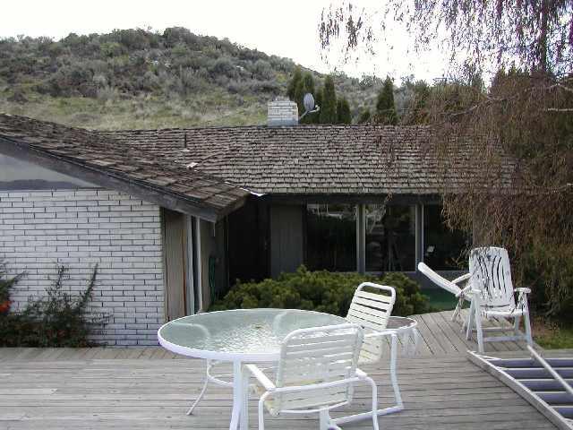 a view of house with backyard space and seating area
