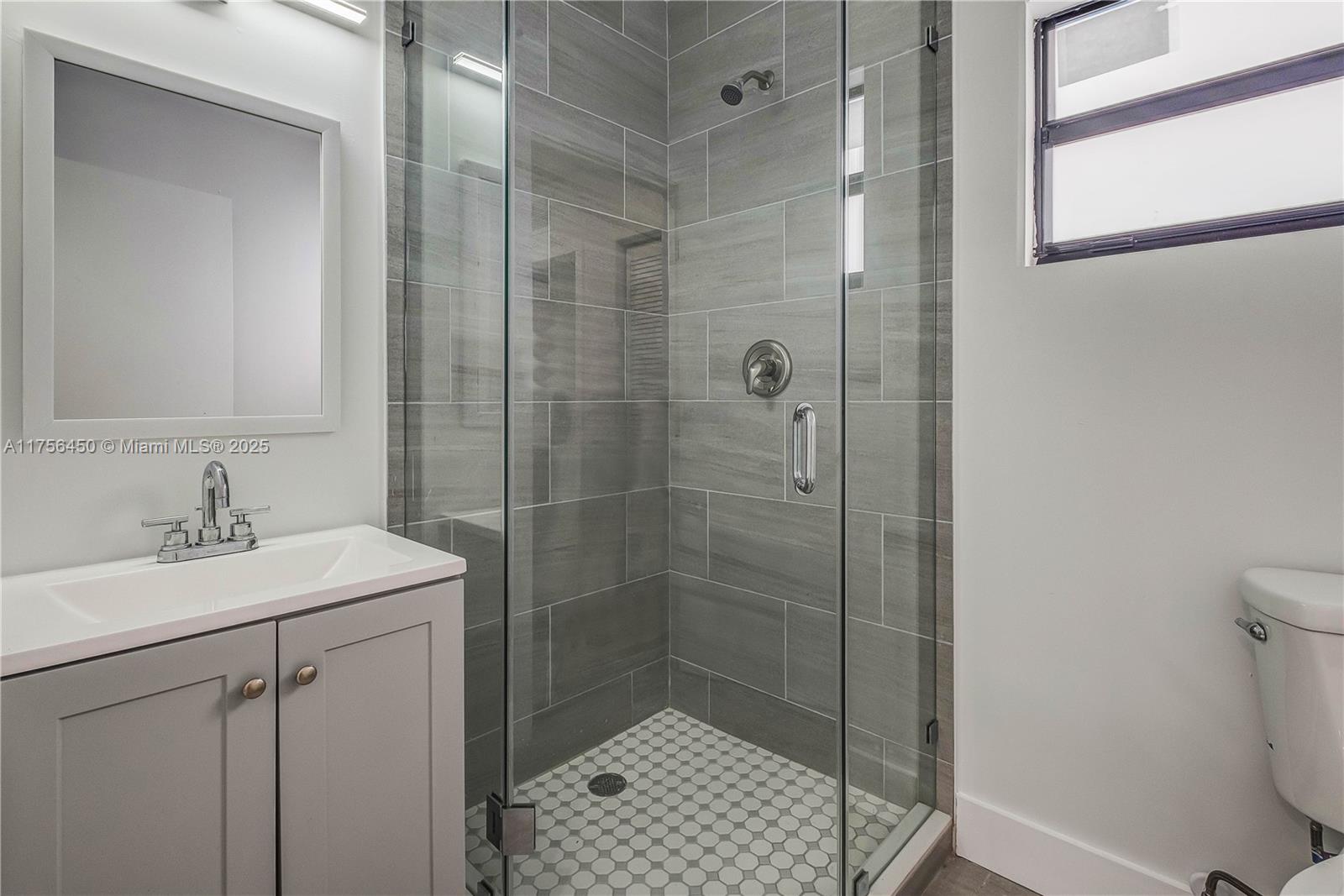 1749 Northwest 64th Street, Unit A Miami, FL 33147 - Photo 16 of 19 a bathroom with a shower a sink and toilet