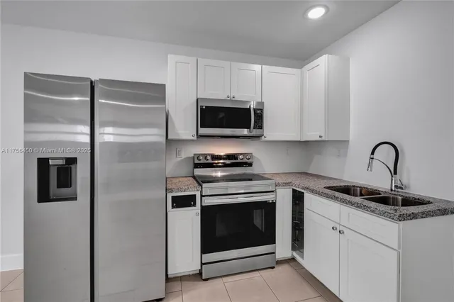 a kitchen with white cabinets and stainless steel appliances
