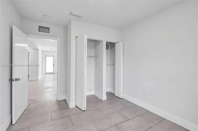 a view of a kitchen with refrigerator and windows