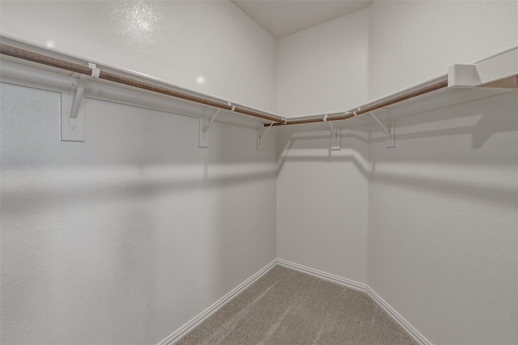 1213 Colca Drive Springtown, TX 76082 - Photo 13 of 23 Walk-in closet with wrap-around shelving and hanging rods, neutral wall finish, and coordinating carpet flooring