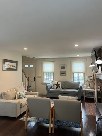 a living room with furniture a large window and a wooden floor