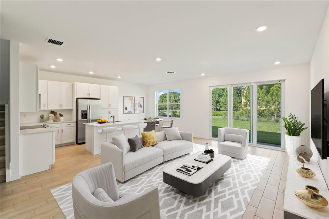 a living room with furniture flat screen tv and a large window