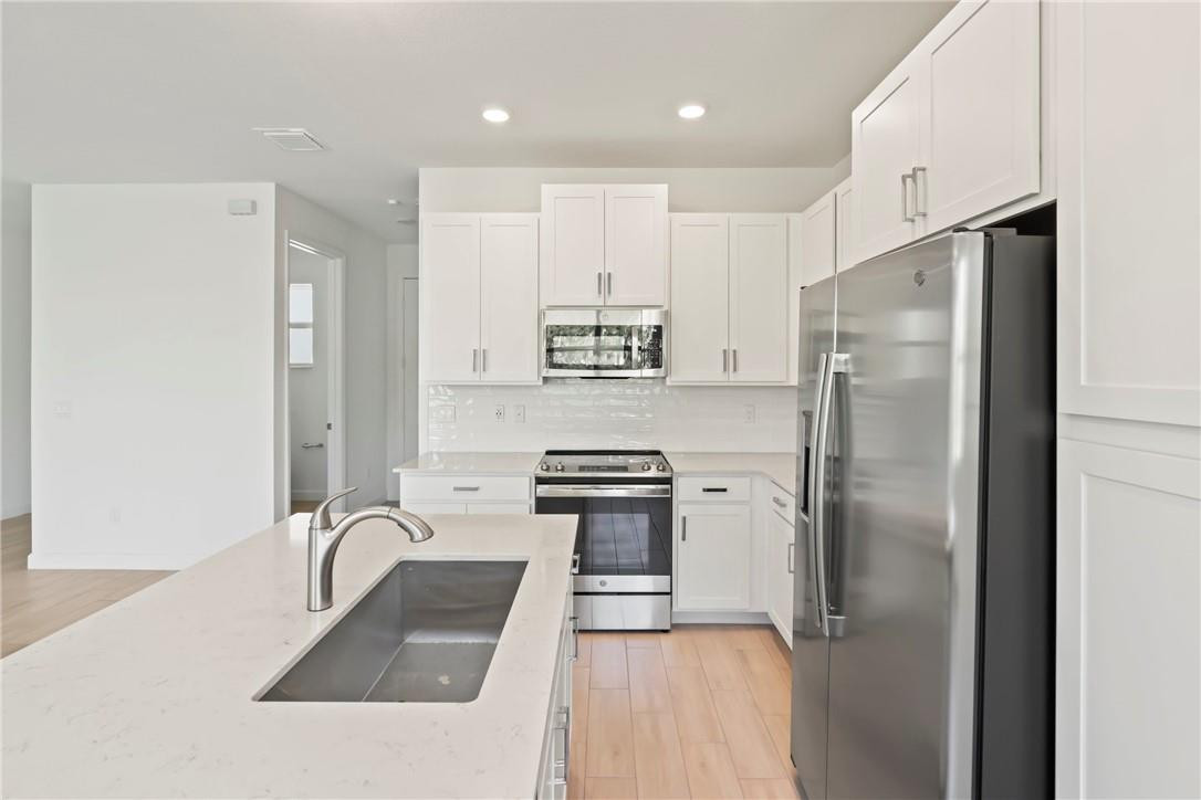 5714 Veranda Way, Unit 2 Boca Raton, FL 33433 - Photo 3 of 24 a kitchen with stainless steel appliances granite countertop a refrigerator a stove and a sink with wooden floor