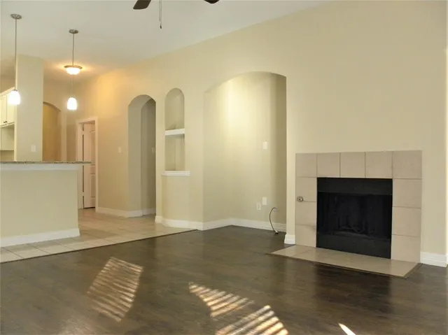 a view of a livingroom with wooden floor and a fireplace
