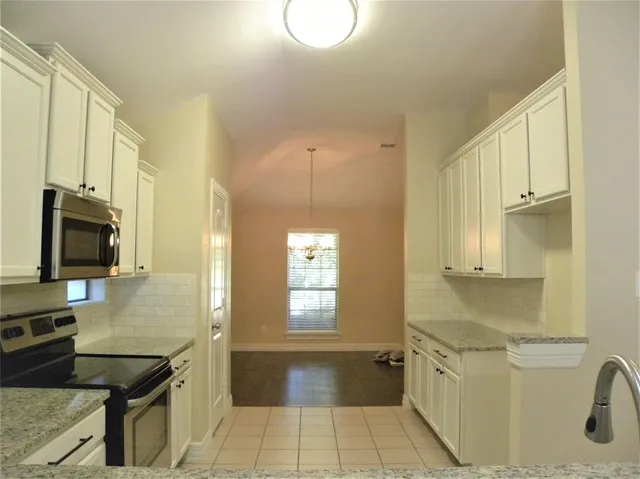 a spacious bathroom with a granite countertop sink a toilet a mirror and shower