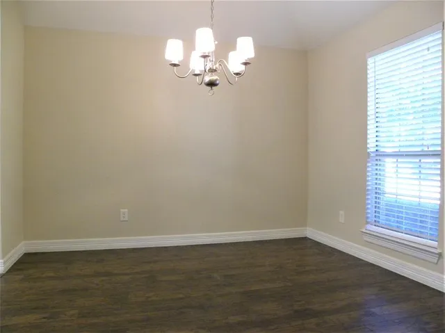 a view of a room with wooden floor and window