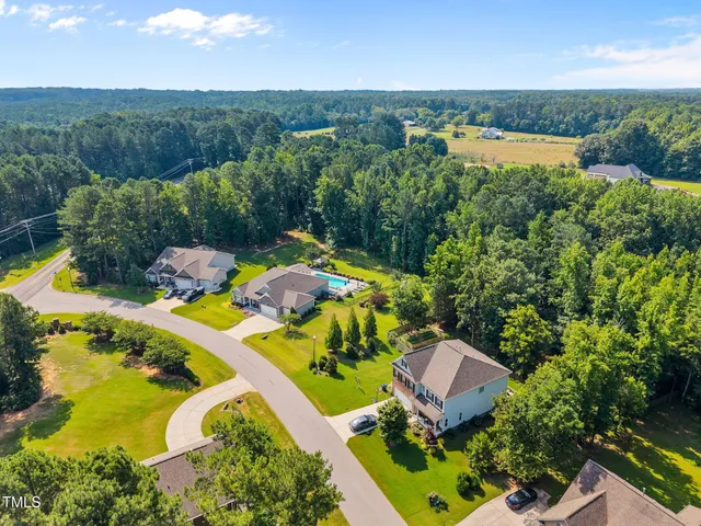 an aerial view of a house with a garden and lake view