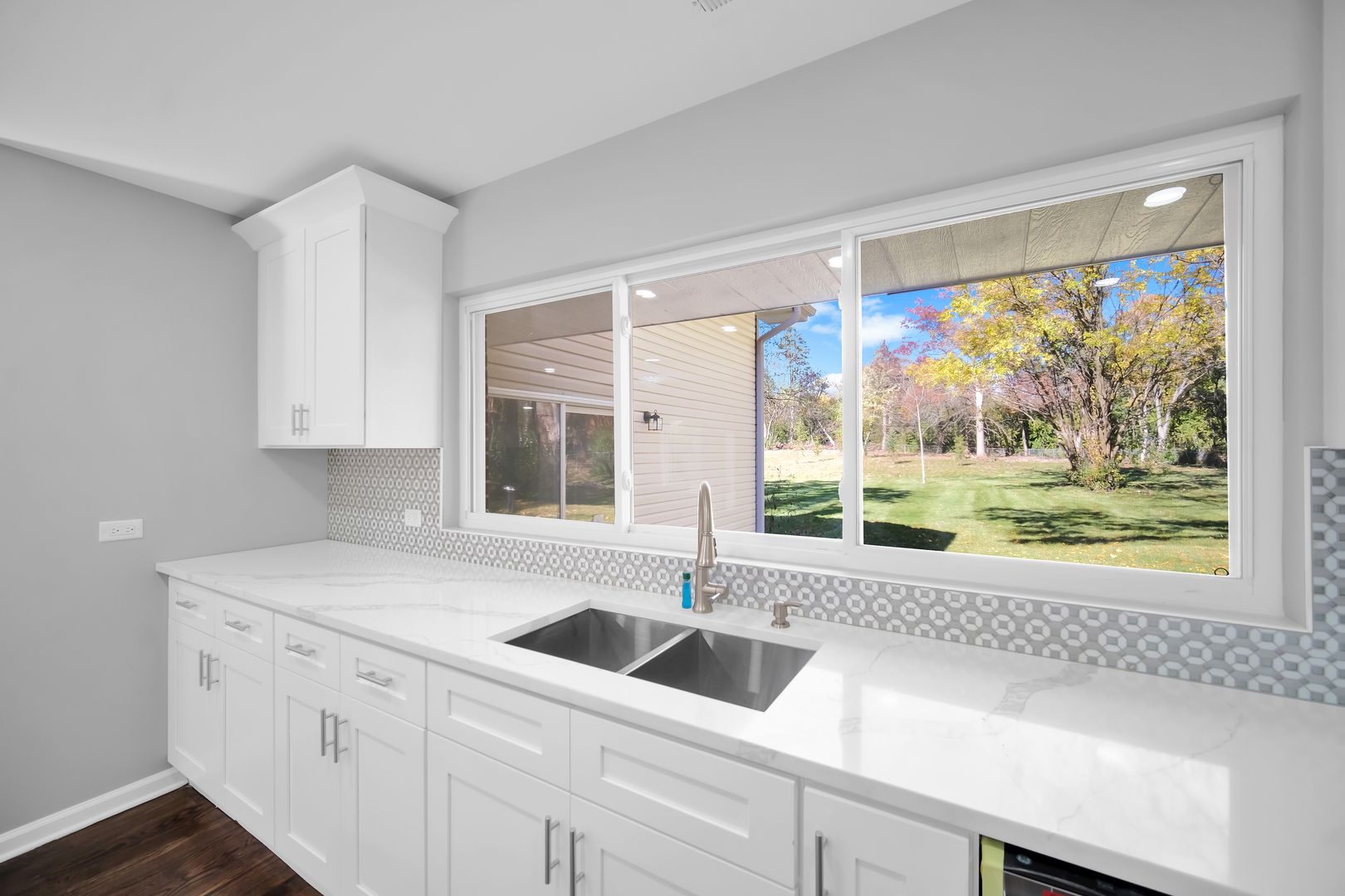 28W360 Roosevelt Road Winfield, IL 60190 - Photo 23 of 50 a kitchen with stainless steel appliances white cabinets a sink and a large window