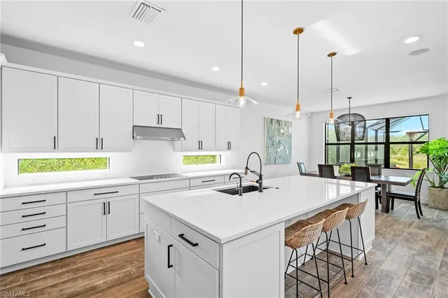 a kitchen with kitchen island a stove a sink a center island and windows