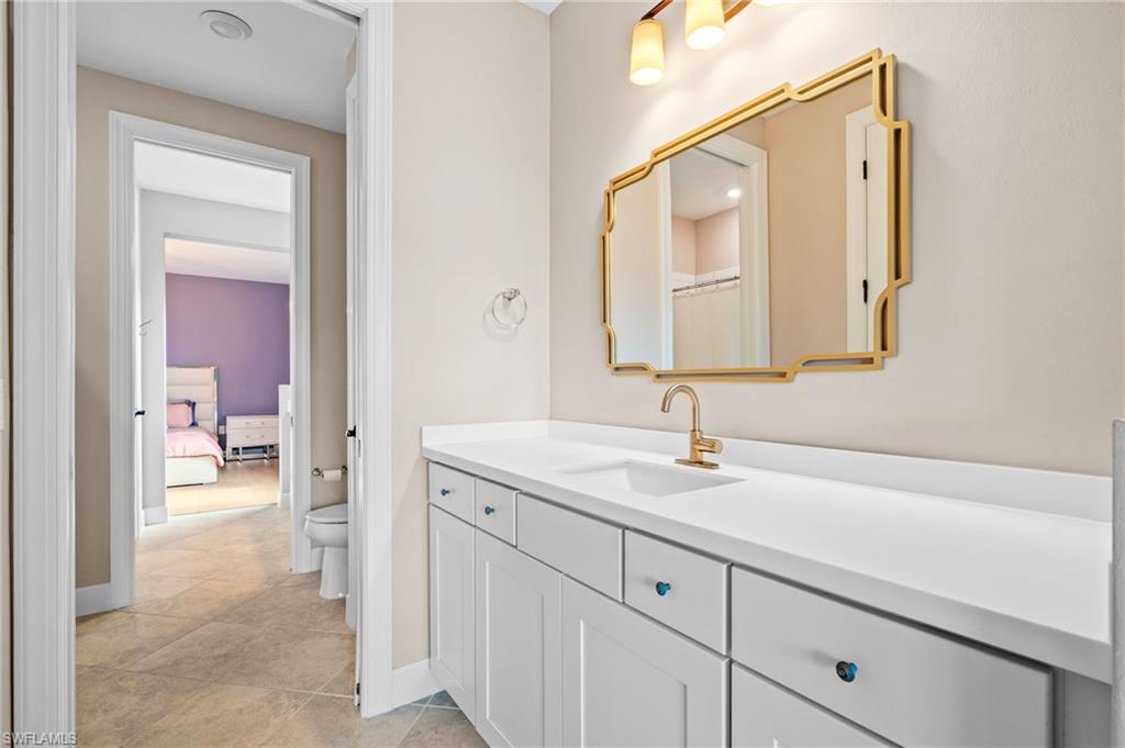 19836 Beverly Park Road Estero, FL 33928 - Photo 23 of 40 a en suite bathroom with a sink a mirror and a