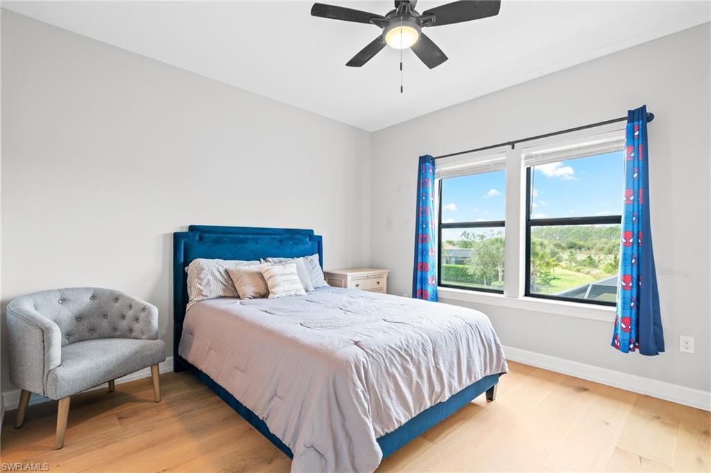 19836 Beverly Park Road Estero, FL 33928 - Photo 26 of 40 a bedroom with a large bed and a chandelier