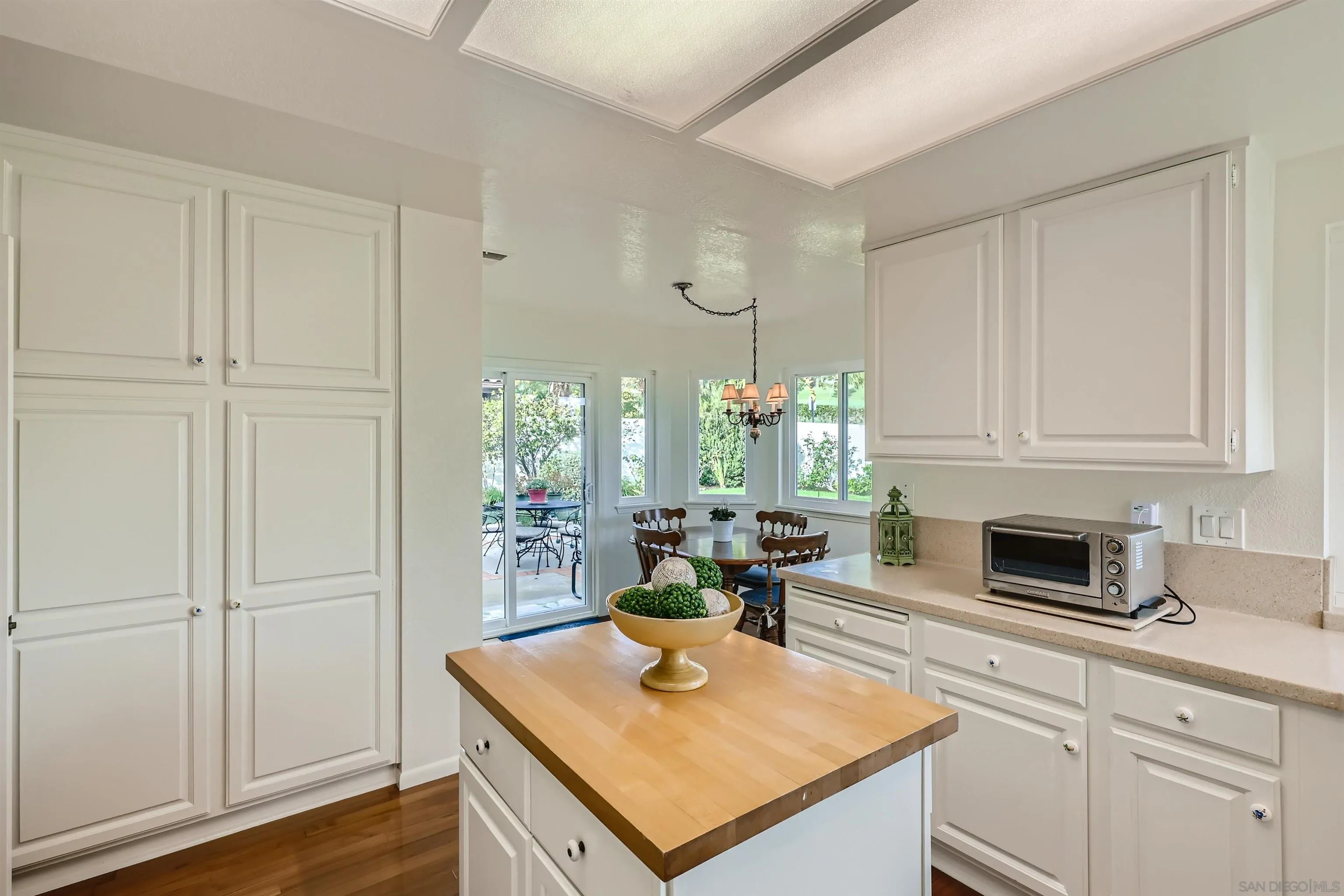 15015 Caminito Ladera Del Mar, CA 92014 - Photo 12 of 25 a kitchen with stainless steel appliances granite countertop a stove a sink and white cabinets with wooden floor