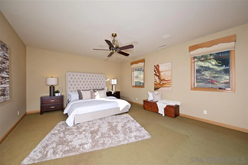 14755 Valleyview Road Poway, CA 92064 - Photo 16 of 24 a spacious bedroom with a bed a couch and a window
