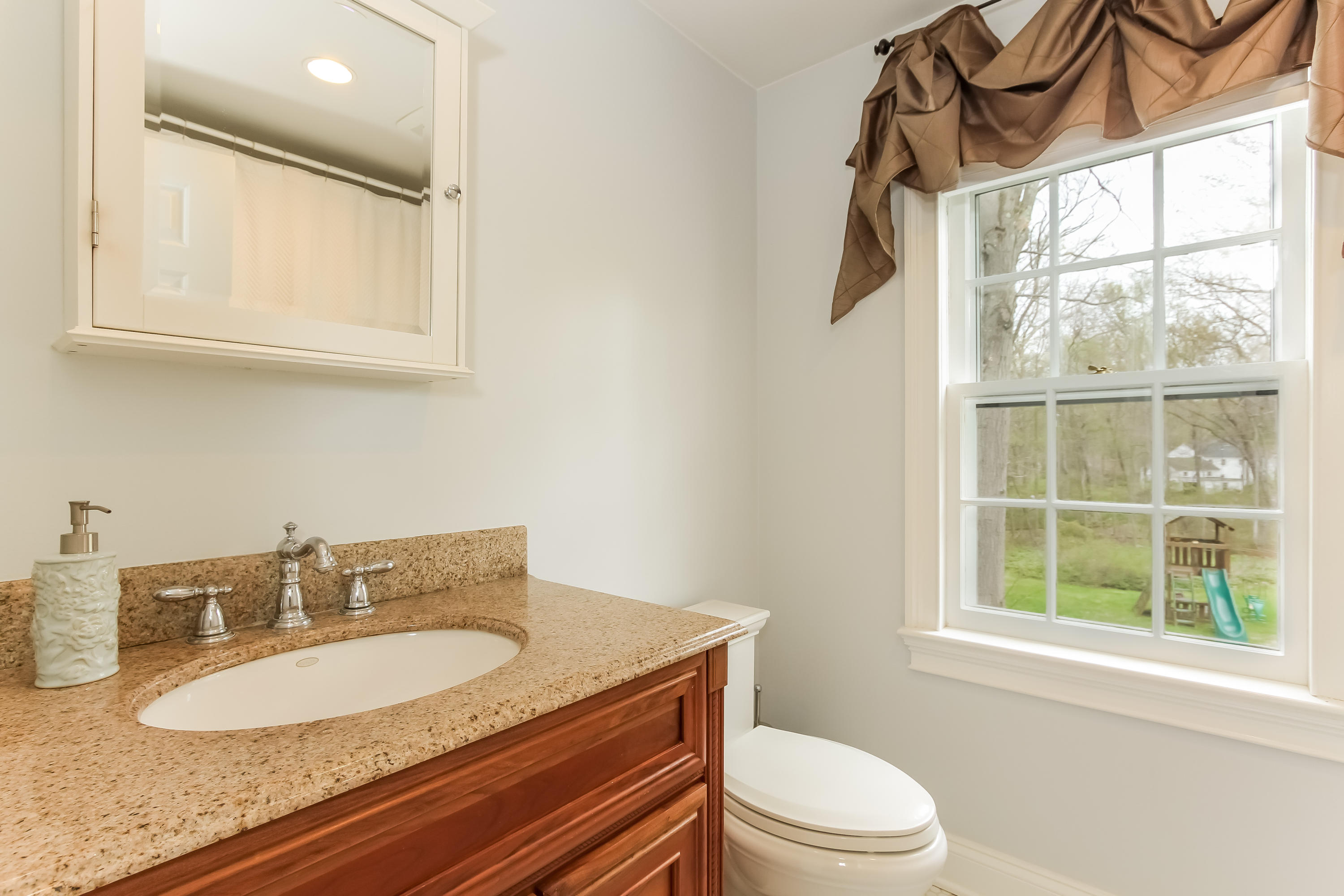 31 Miller Road Darien, CT 06820 - Photo 18 of 29 a bathroom with a granite countertop sink toilet and a mirror