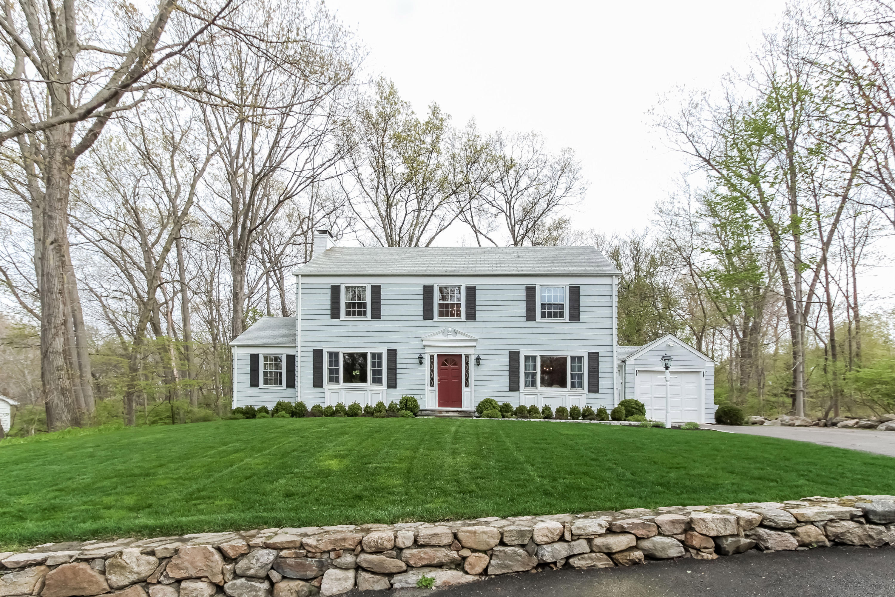 31 Miller Road Darien, CT 06820 - Photo 2 of 29 a front view of a house with a garden and trees