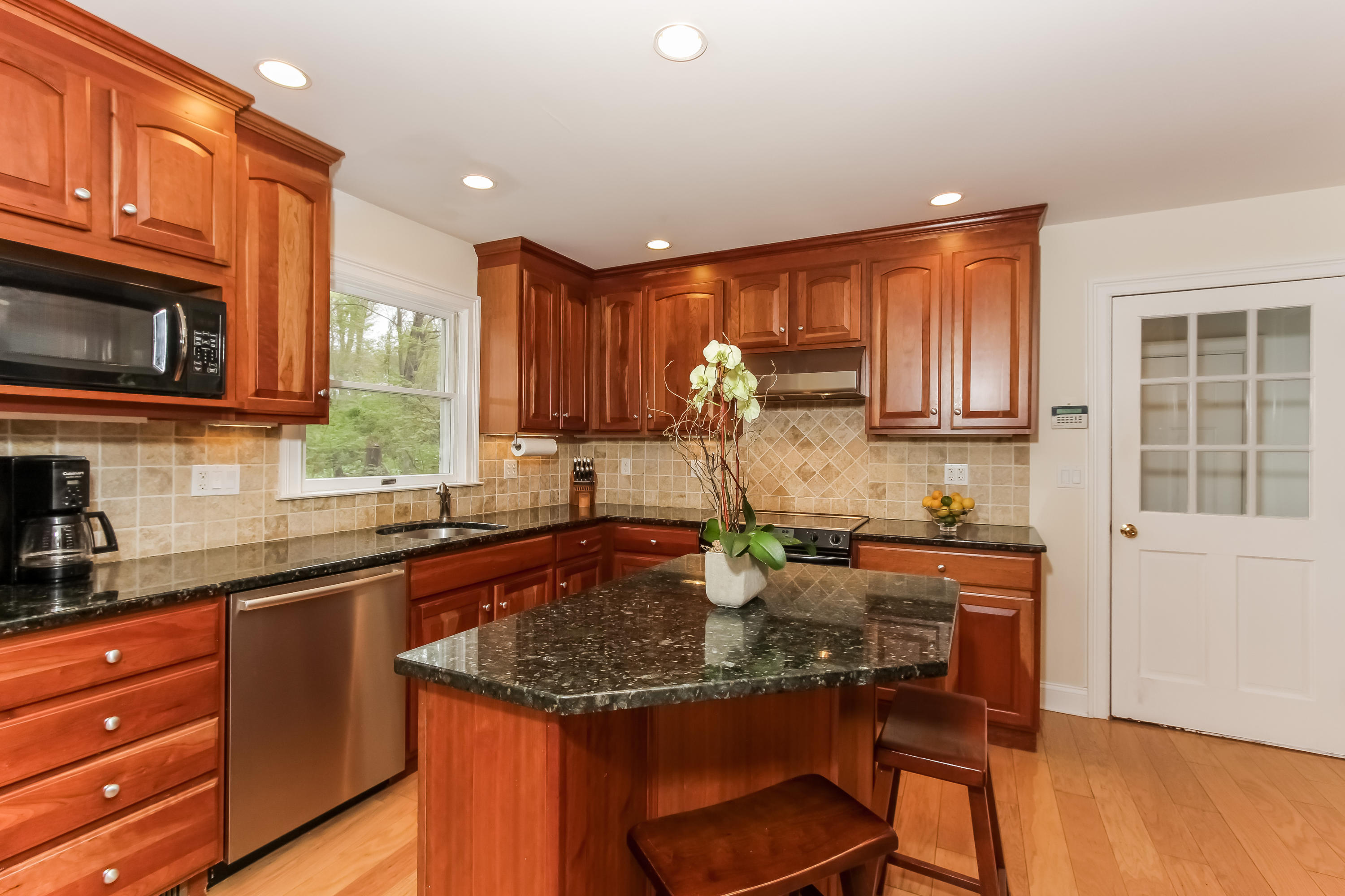 31 Miller Road Darien, CT 06820 - Photo 9 of 29 a kitchen with a stove a sink a microwave cabinets and wooden floor