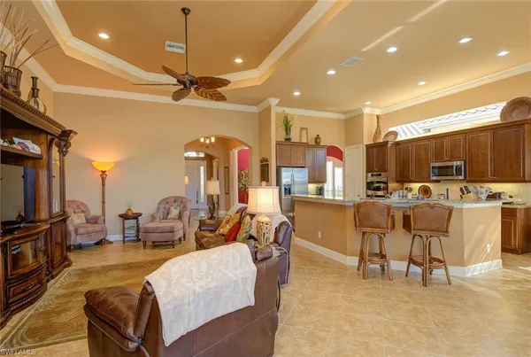 a living room with couches a flat screen tv and kitchen view