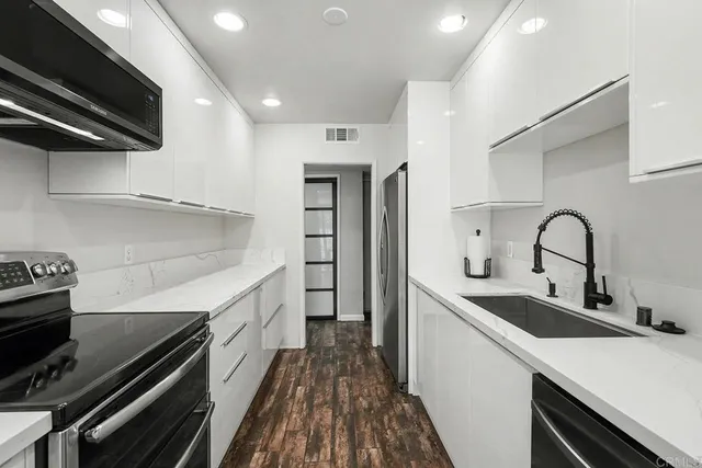 a kitchen with sink a microwave and cabinets