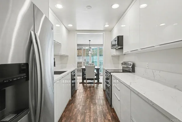 a kitchen with white cabinets and stainless steel appliances