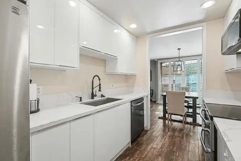 a kitchen with a sink cabinets and wooden floor