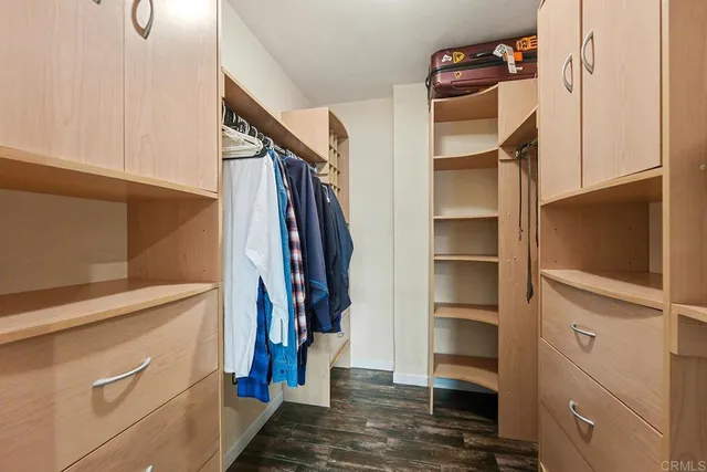 a view of walk in closet with clothes and shoes