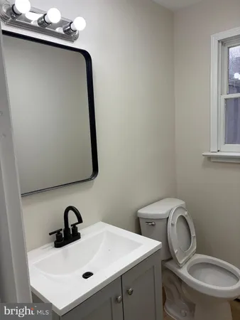 a bathroom with a toilet sink and mirror