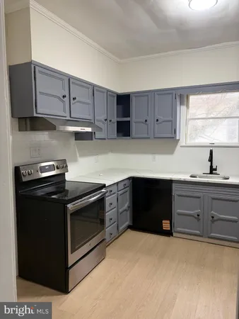 a kitchen with wooden cabinets and a stove top oven