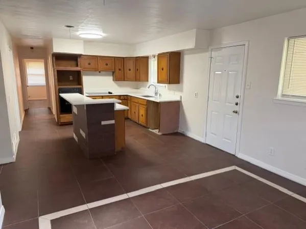 a kitchen with a sink cabinets and wooden floor