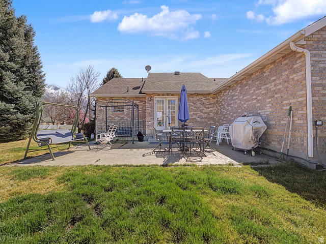 598 West 1600th Street North Mapleton, UT 84664 - Photo 23 of 34 Back of property featuring a patio, a lawn, roof with shingles, brick siding, and outdoor dining area