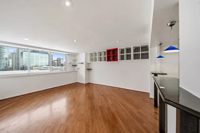 a view of a kitchen with wooden floor and a window