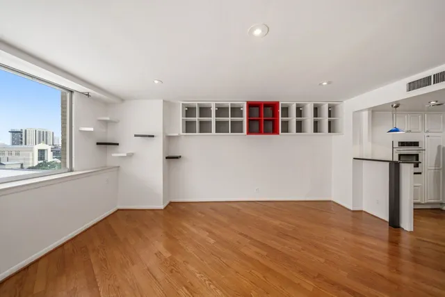 a view of empty room with wooden floor and windows