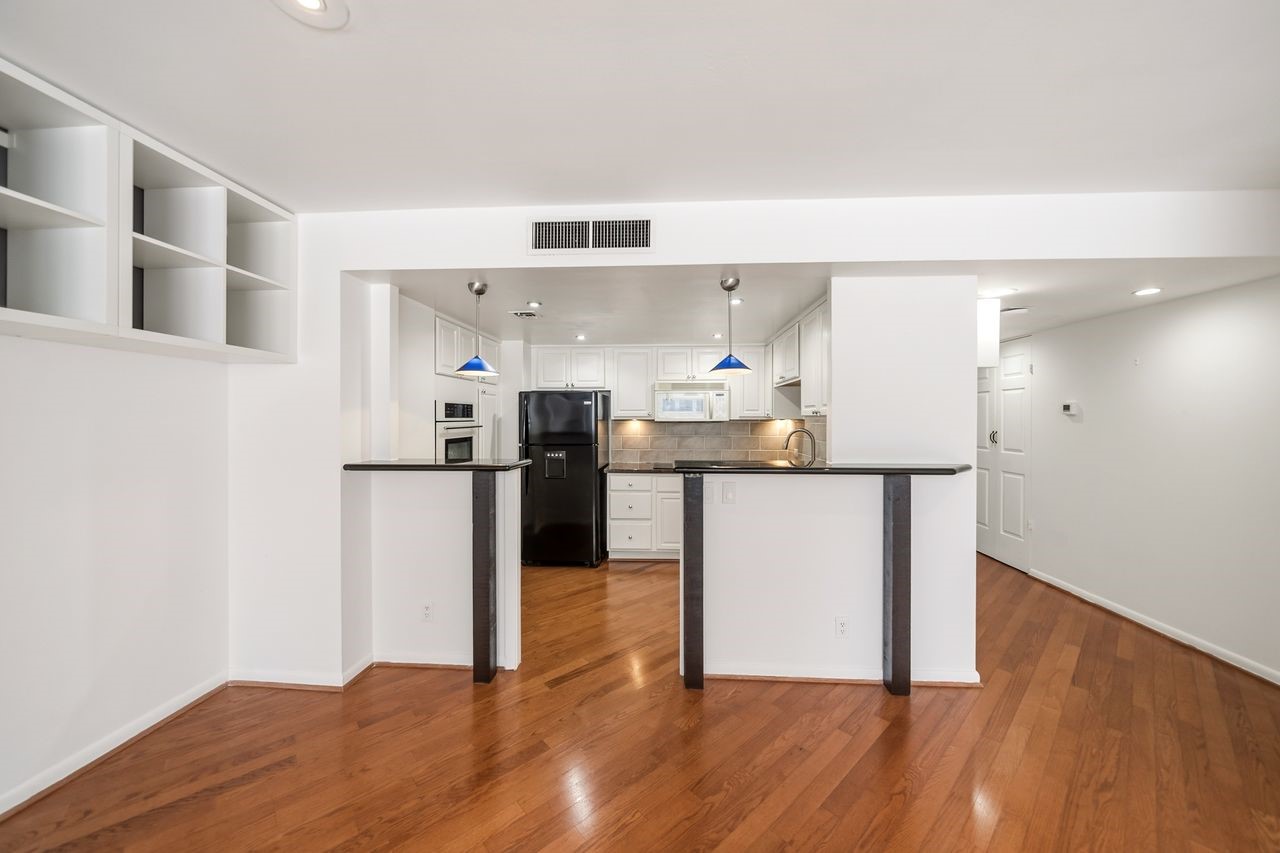 2016 Main Street, Unit 701 Houston, TX 77002 - Photo 6 of 43 a kitchen with granite countertop a refrigerator and a stove top oven