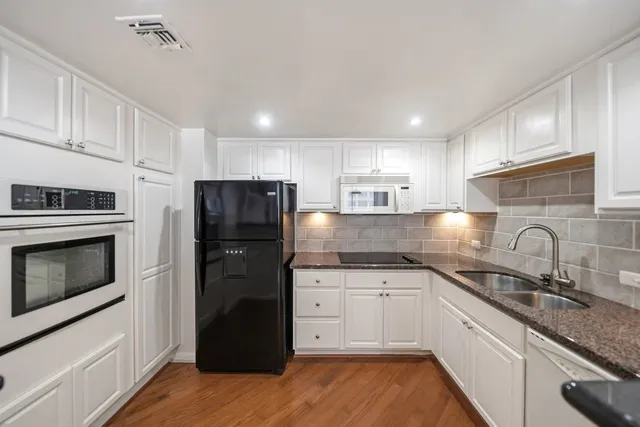 a kitchen with a sink a refrigerator and cabinets
