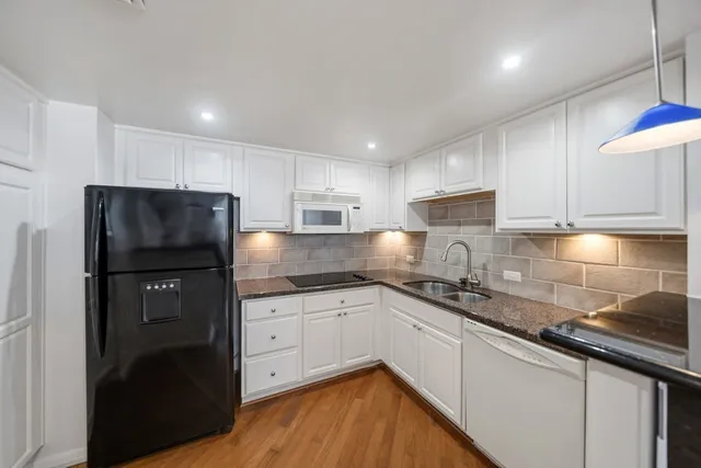 a kitchen with a sink a refrigerator and cabinets