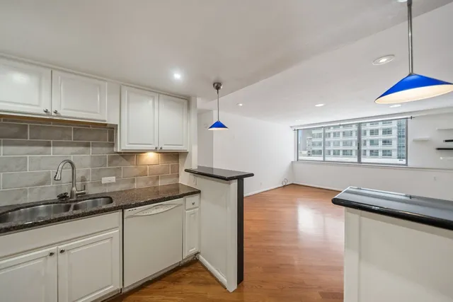a kitchen with kitchen island granite countertop a sink cabinets and window