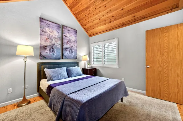 a bedroom with a bed and a painting on the wall